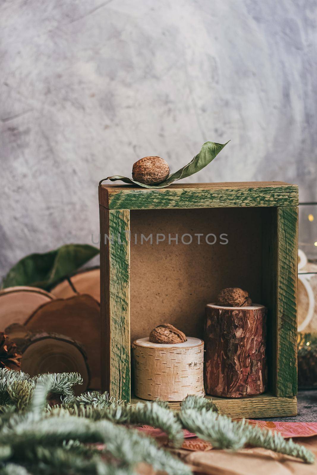 Christmas composition with nuts, rustic wooden box and fir tree branch. Decorated by festive decor. Rustic style.