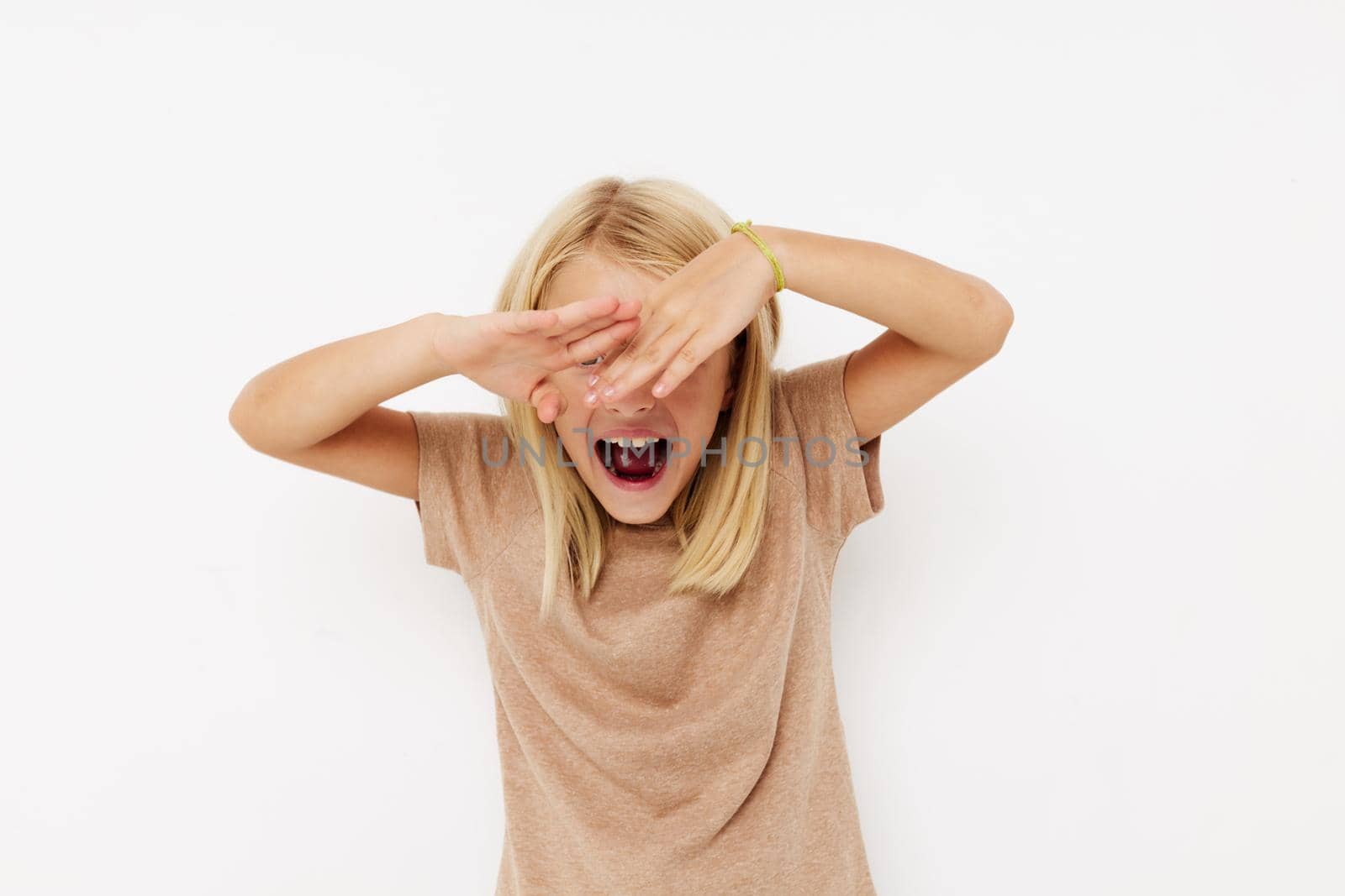 happy cute girl in a beige t-shirt on a light background. High quality photo