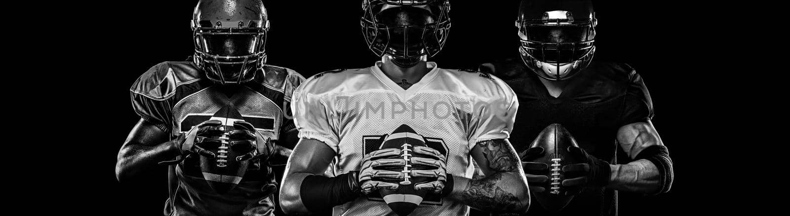 American football player, sportsman in helmet on dark background. Black and white photo. Sport wallpaper. by MikeOrlov
