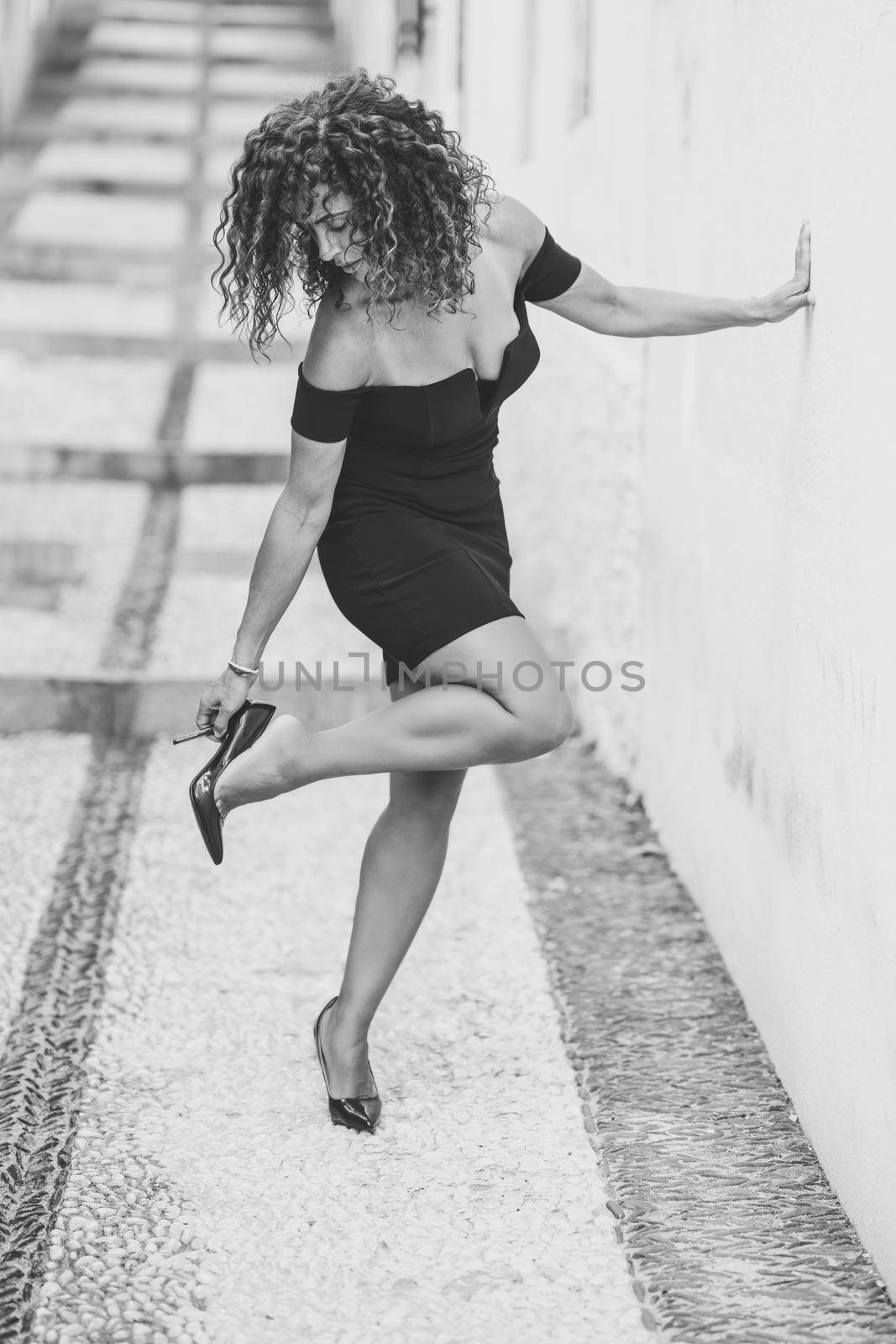 Beautiful brunette middle-aged woman wearing dress and high heels outdoors by javiindy