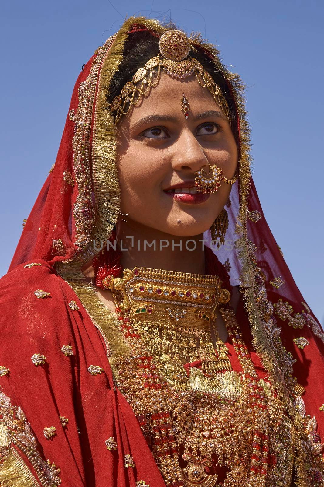 Jaisalmer, Rajasthan, India - February 19, 2008: Indian lady dressed in ornate red sari and adorned with traditional Indian jewellery at the annual Desert Festival in Jaisalmer.