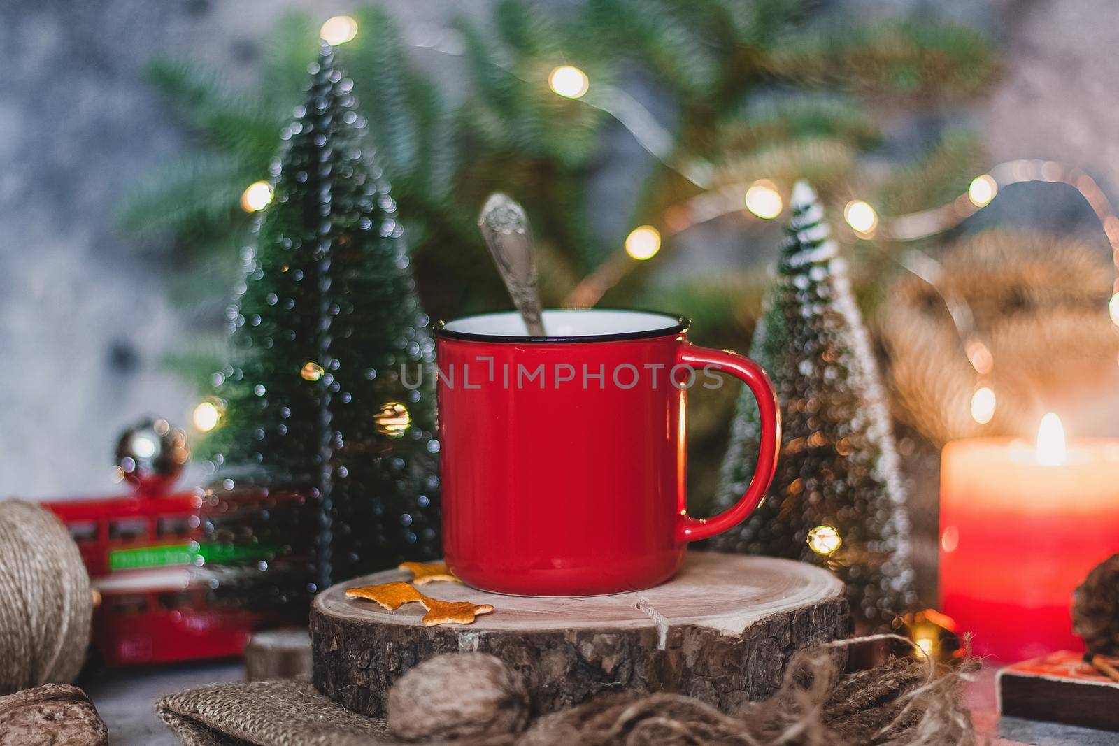 Cozy winter drink hot chocolate cocoa in red mug with fir tree, candles and Christmas lights. by mmp1206