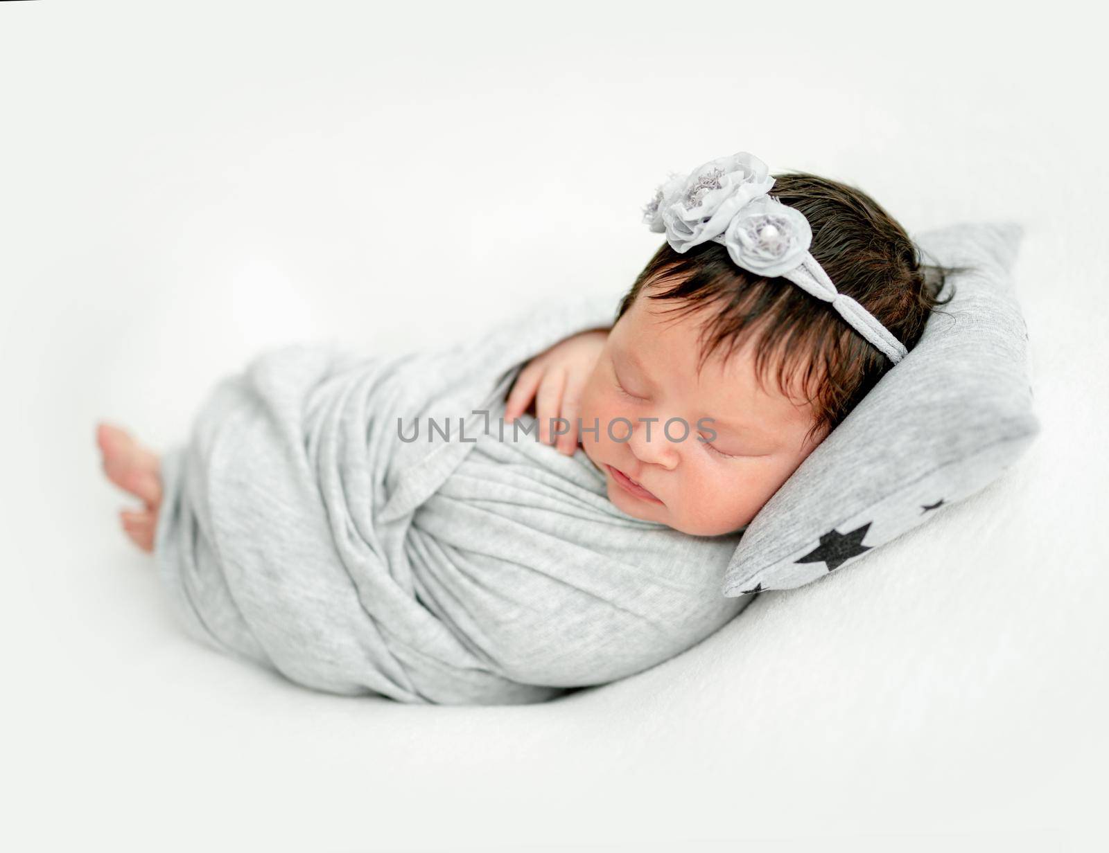 newborn baby girl sleeping sweetly on a little pillow