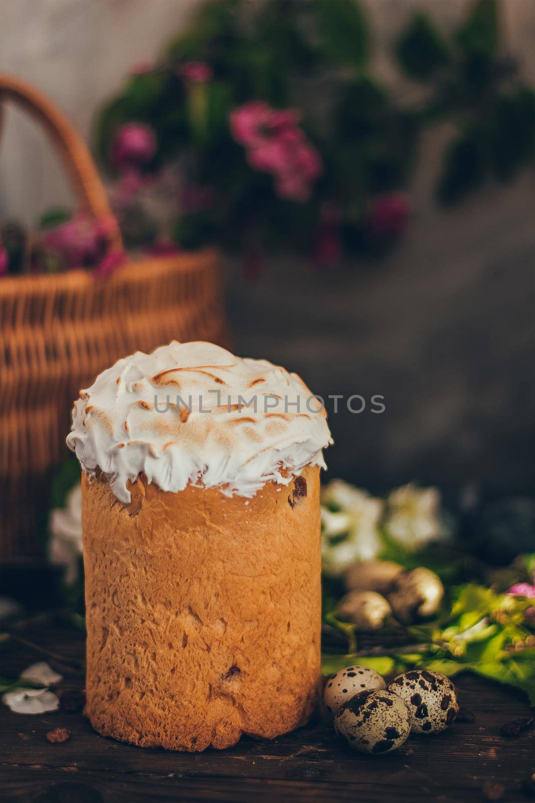 Traditional Russian Orthodox Easter bread kulich with apple blossom and colored eggs in rustic style background with a basket by mmp1206