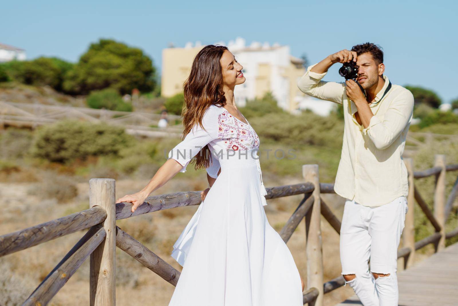 Man photographing his girlfriend on a lovers' trip Couple enjoying a natural environment.