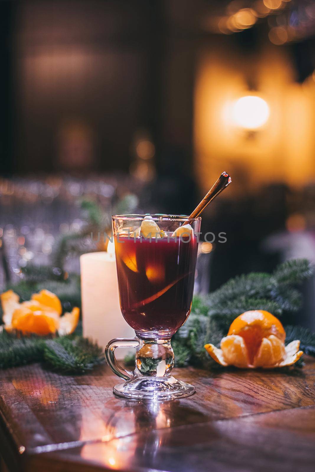 Red hot drink glintwein with spices, cinnamon, anise, fruits, brown sugar on an old wooden table. New Year and Christmas holidays concept. Mulled wine and glintwein