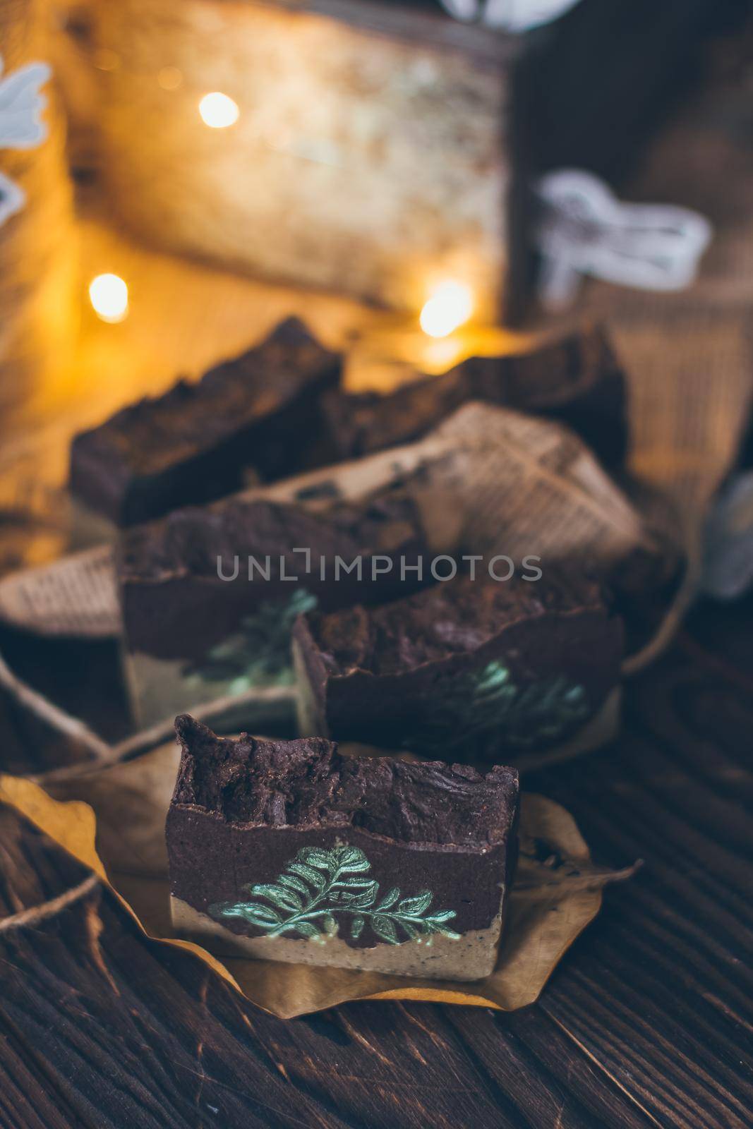 Pieces of beautiful natural handcrafted soap on wooden background with botanical elements, close up view. For relax, health, spa and aromatherapy.