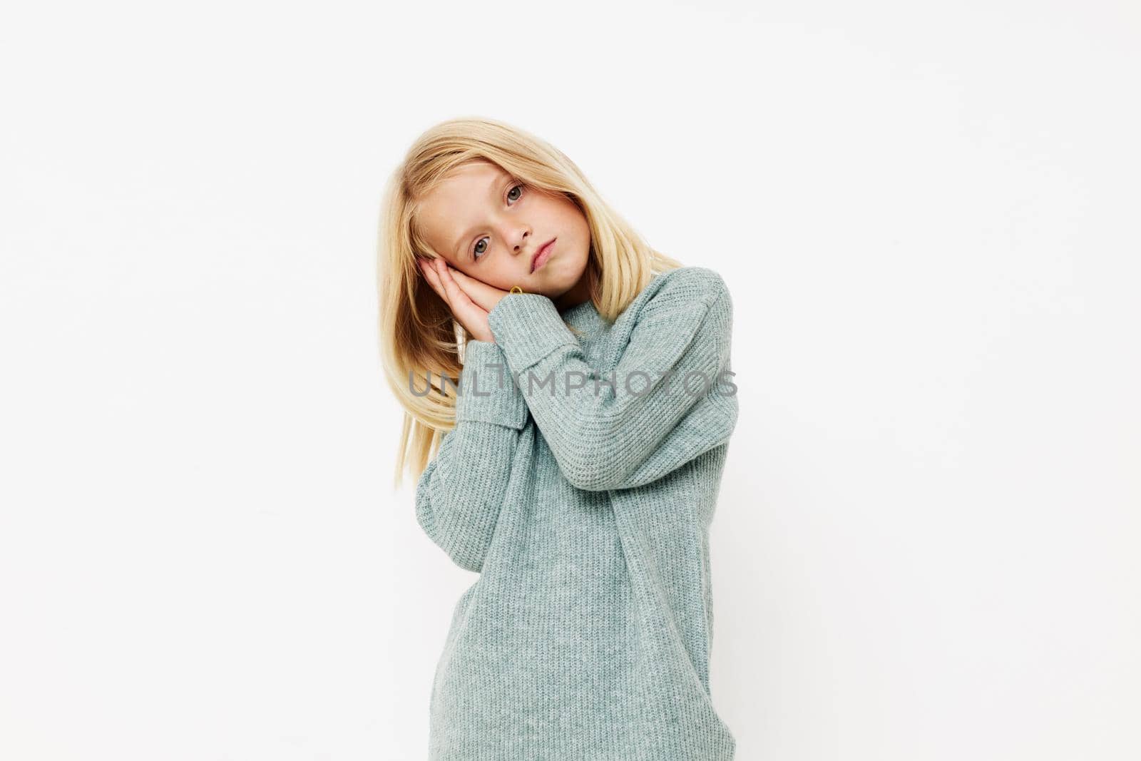 Positive little girl gestures with his hands on a light background. High quality photo