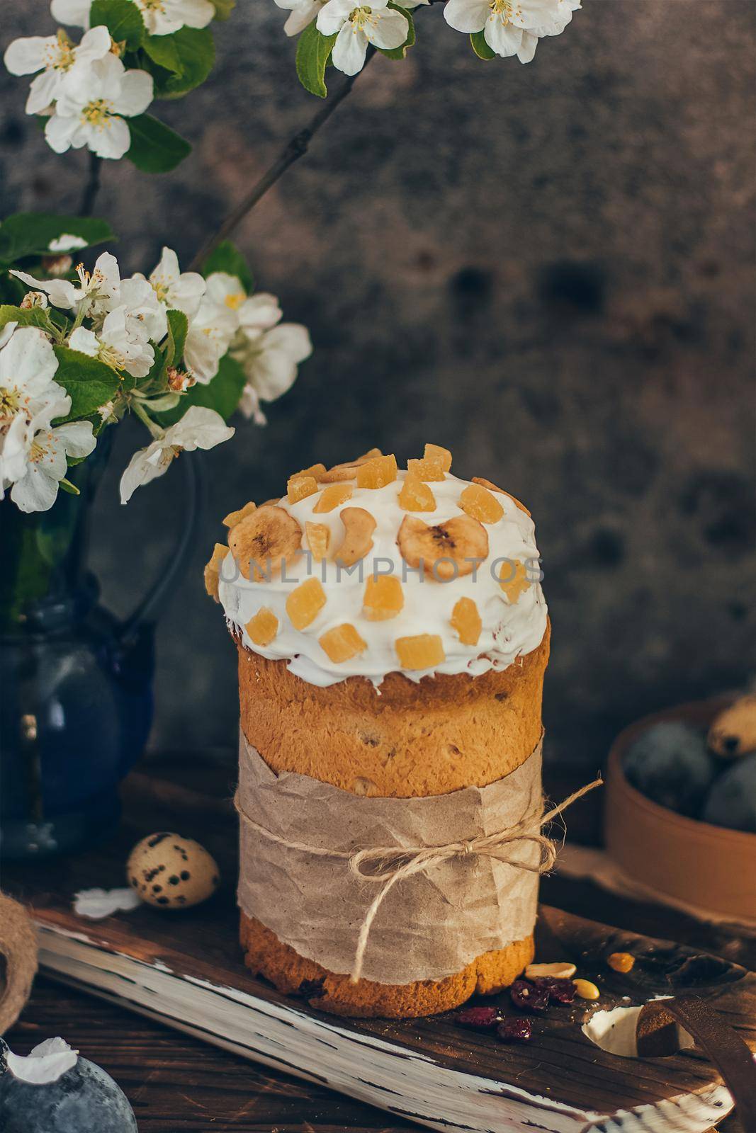 Traditional Russian Orthodox Easter bread kulich with apple blossom and colored eggs in rustic style background by mmp1206