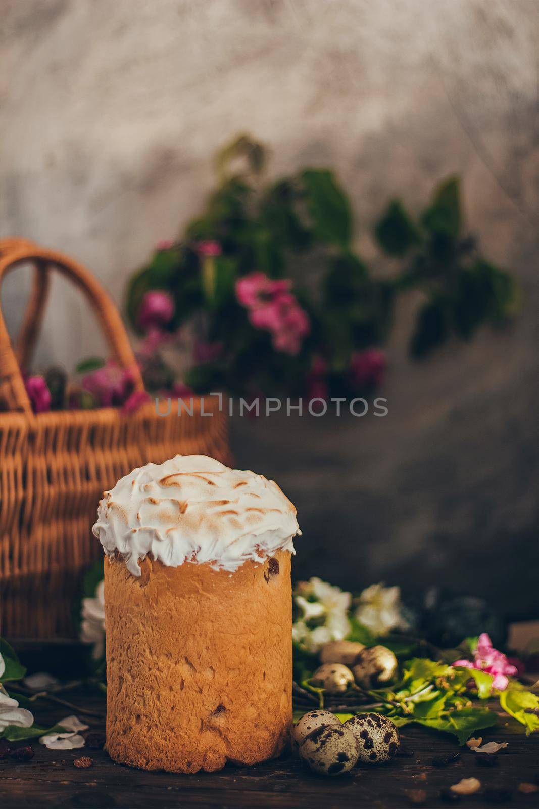 Traditional Russian Orthodox Easter bread kulich with apple blossom and colored eggs in rustic style background with a basket by mmp1206