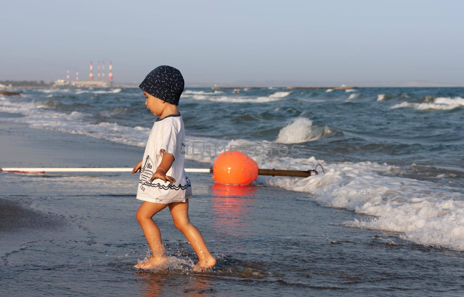 LIMASSOL, CYPRUS, Jun 19, 2010: A little boy walks for the first time along the seashore enjoying the fresh air and sea waves