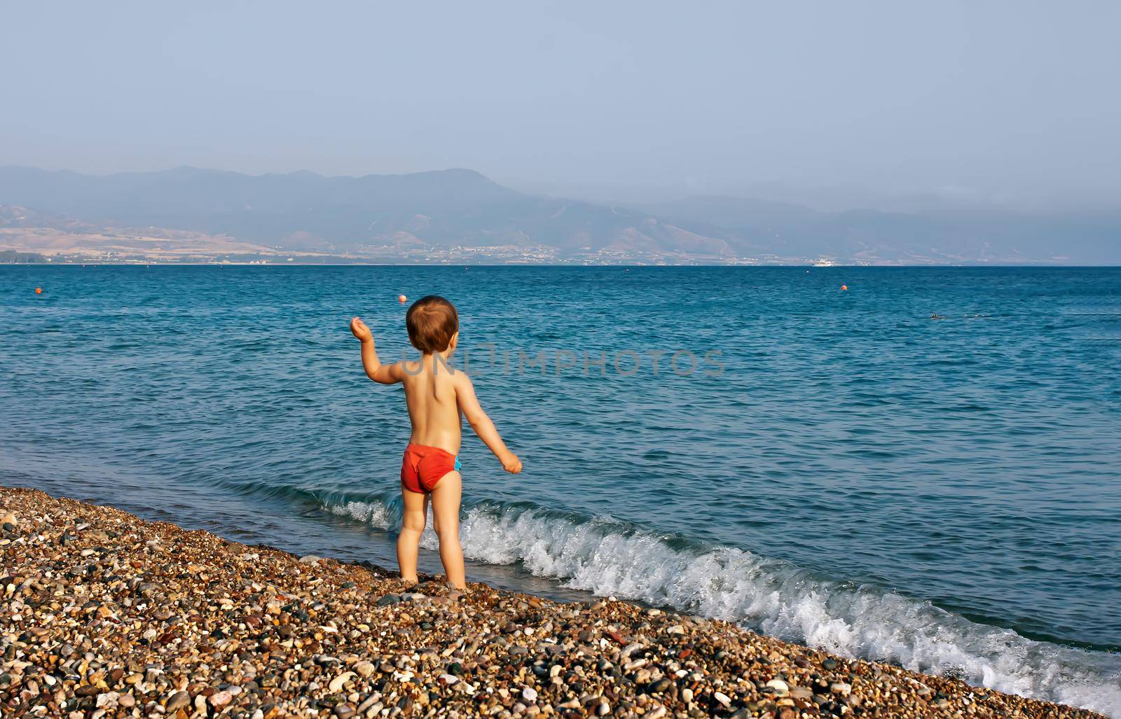 Healthy lifestyle. A little boy walks and plays on the seashore.