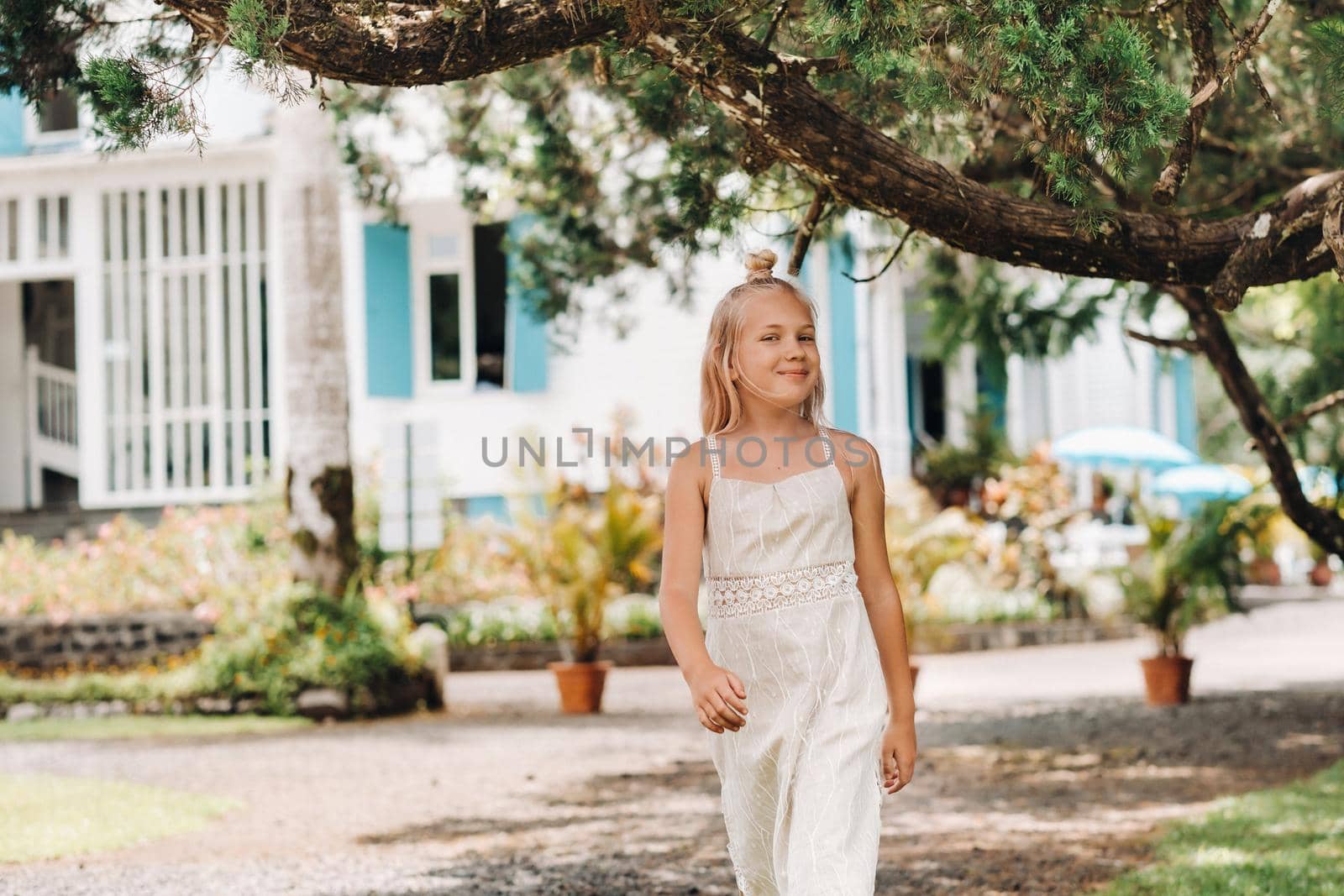 Summer portrait of a happy little girl on the island of Mauritius.beautiful smile, summer white dress. by Lobachad