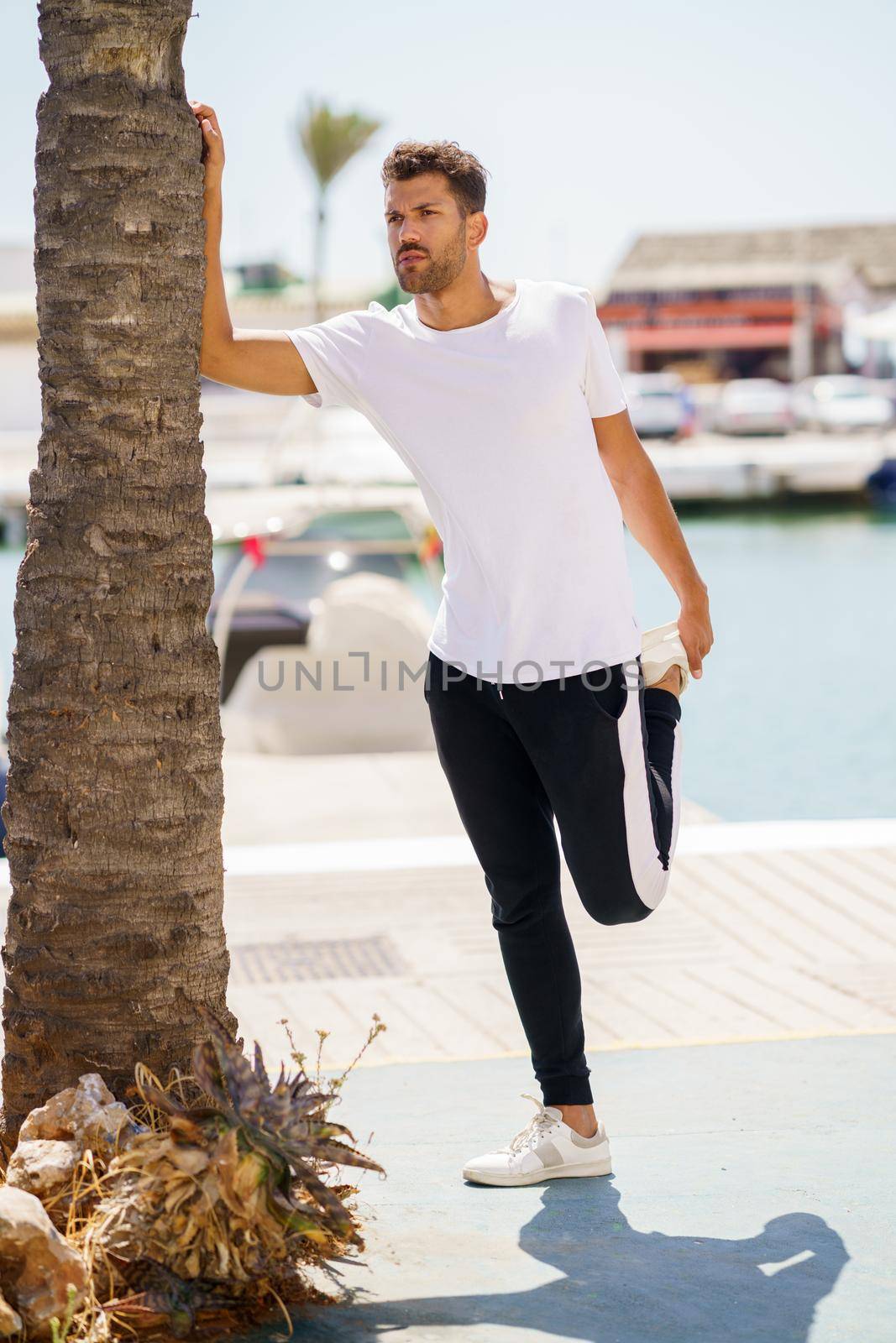 Young man stretching after exercise in a harbour