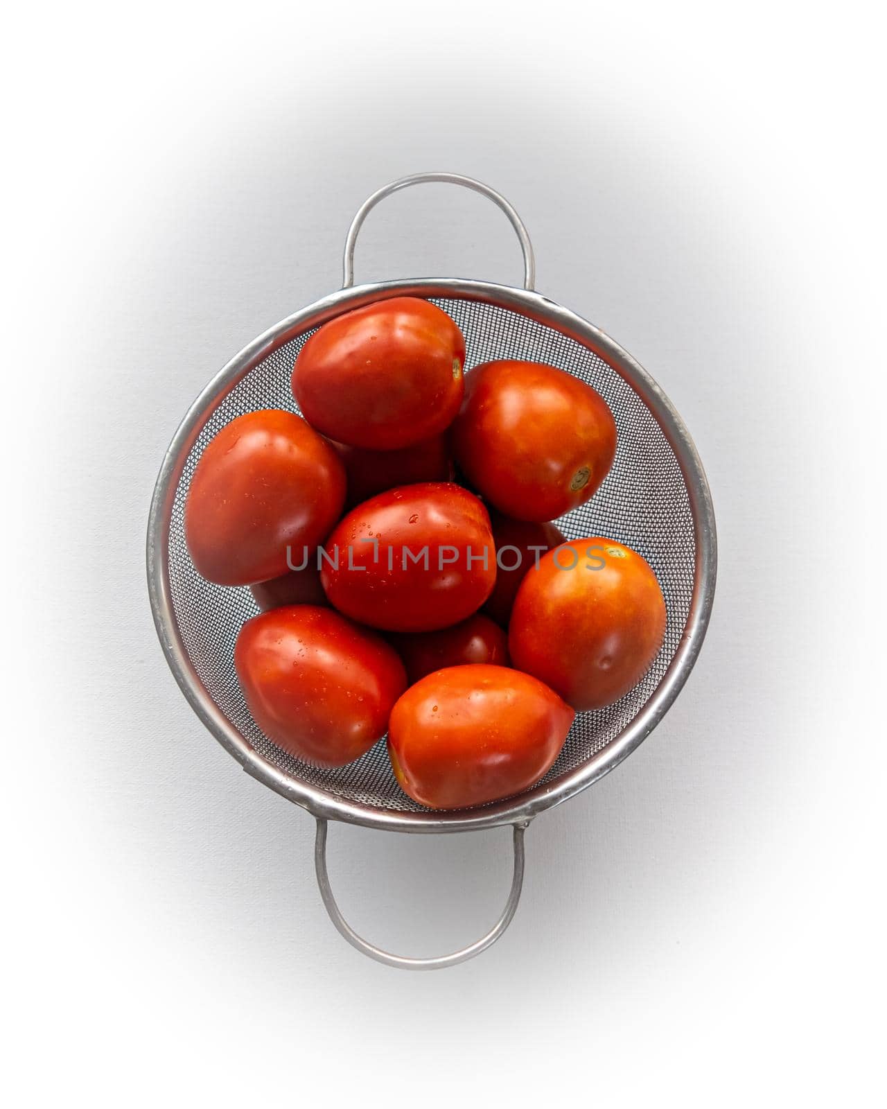 Close up image of Fresh red tomatoes washed with water and kept in a net pot with plain white background. by lalam