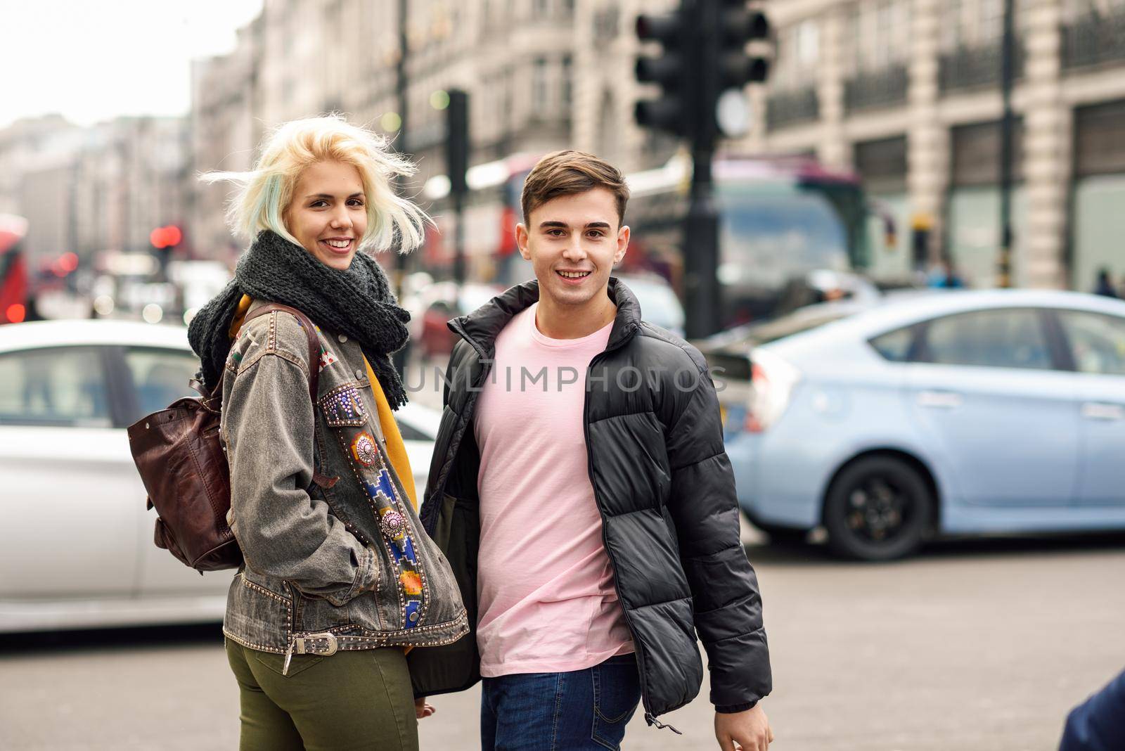 Happy couple of friends enjoying view during travel in London. Teenager guy and girl in urban background.