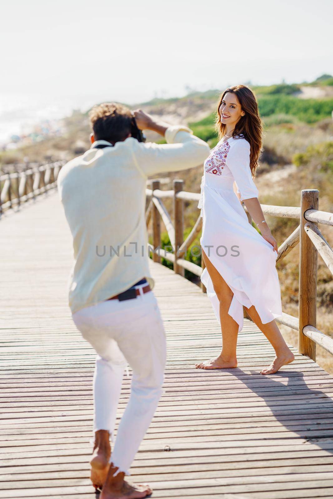 Man photographing his girlfriend on a lovers' trip Couple enjoying a natural environment.