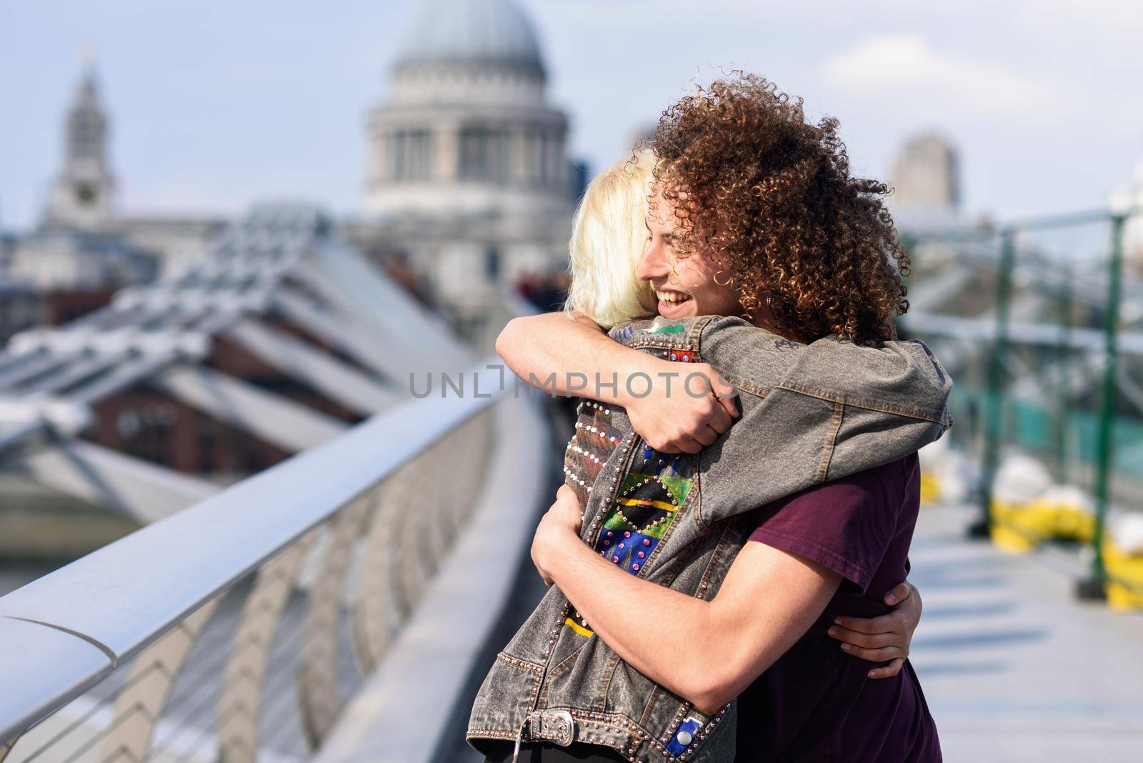 Happy couple hugging by Millennium bridge, River Thames, London. UK
