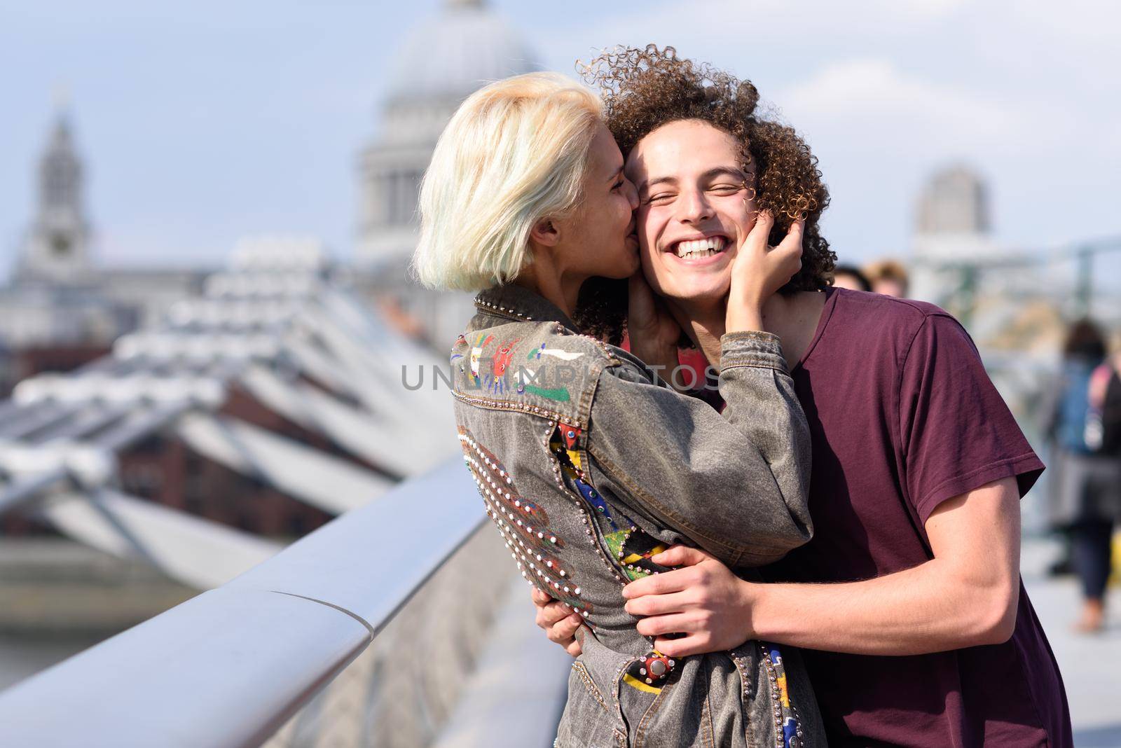Happy couple hugging by Millennium bridge, River Thames, London. by javiindy