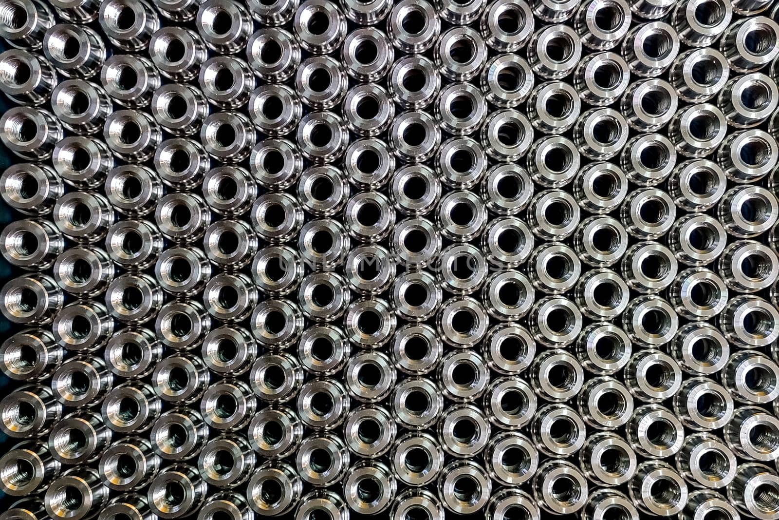 Close up pattern image of stacked stainless steel semi-finished components ready for further processing.