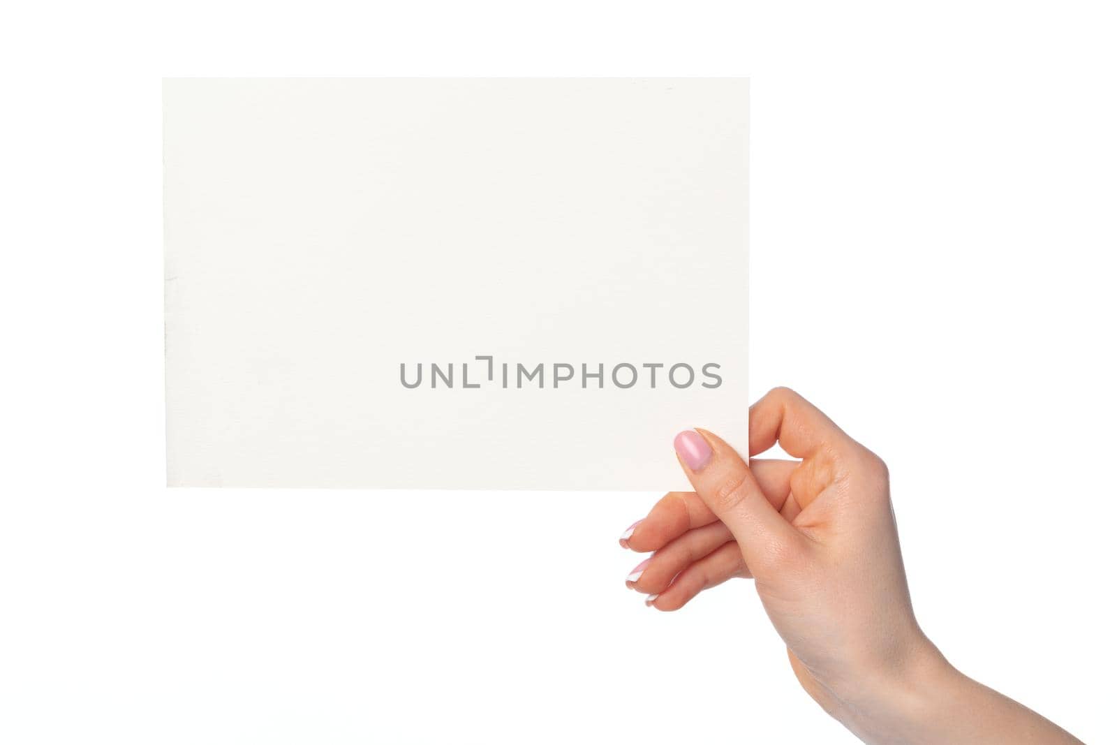 Woman's hand holding blank white sheet of paper isolated on white background