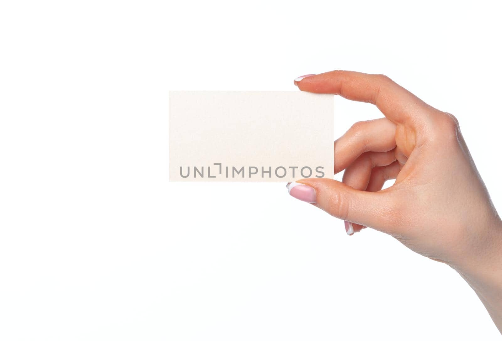 Beautiful female hand holding white business card isolated on white background