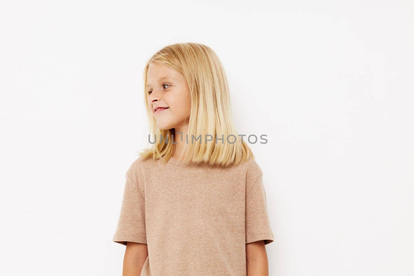 Portrait of a smiling little cutie in a beige t-shirt lifestyle concept. High quality photo