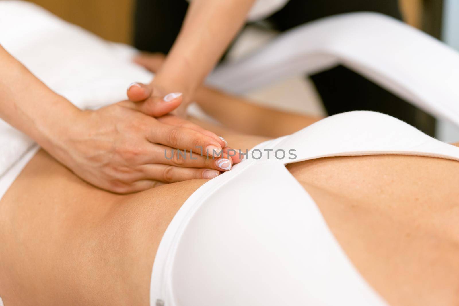 Middle-aged woman having a belly massage in a beauty salon. by javiindy