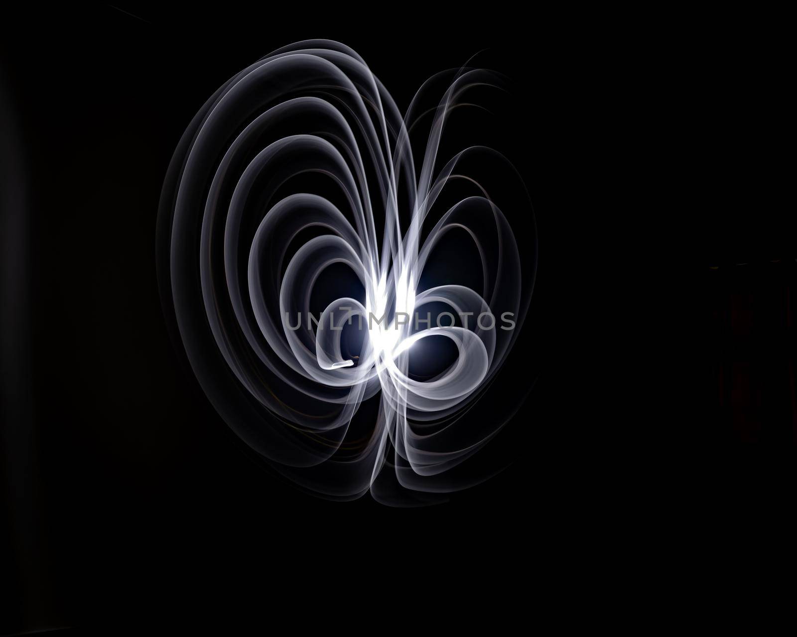 Unique, long exposure, white Led light painting photograph of abstract pattern on black background.