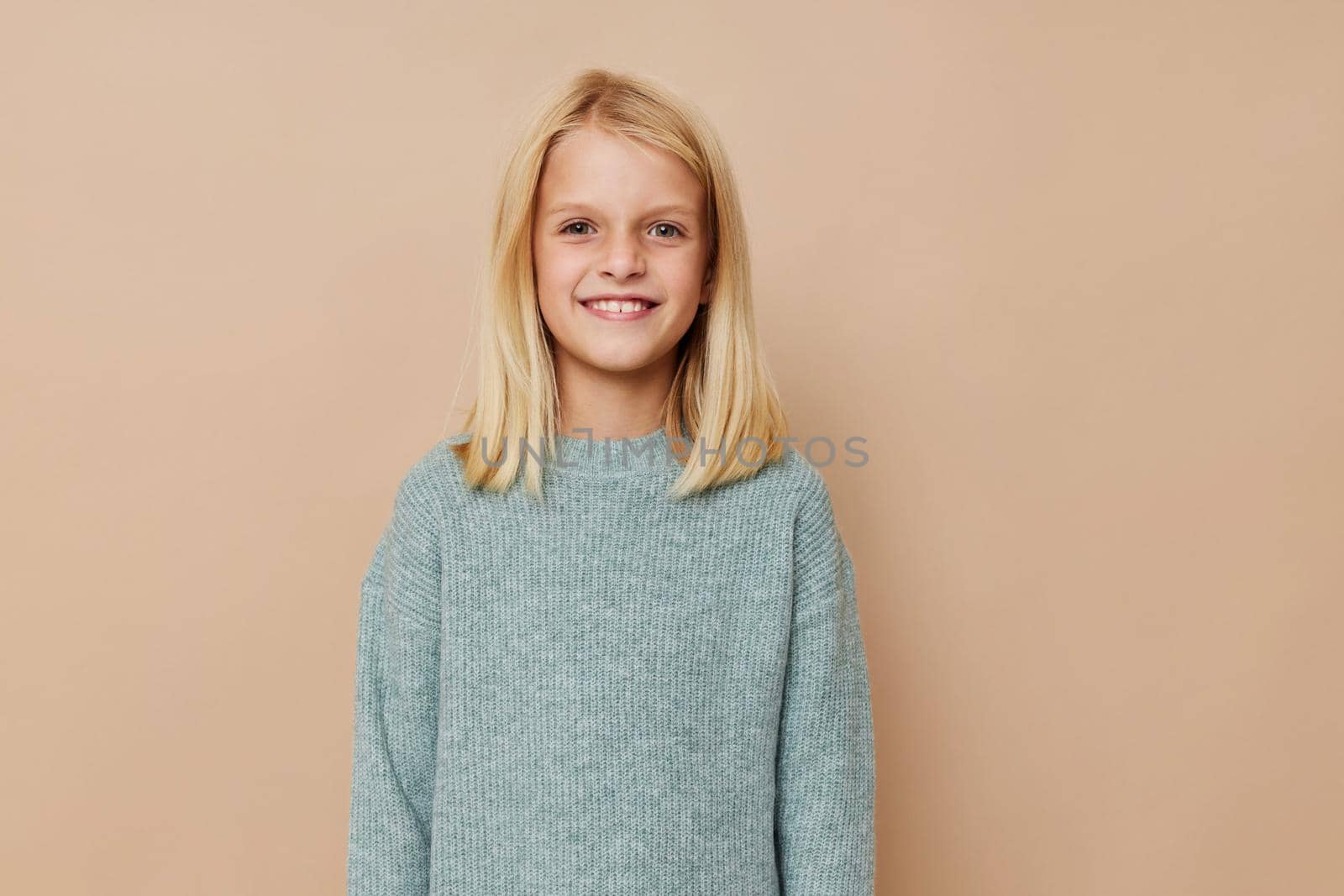 Positive little girl with blond hair posing studio. High quality photo
