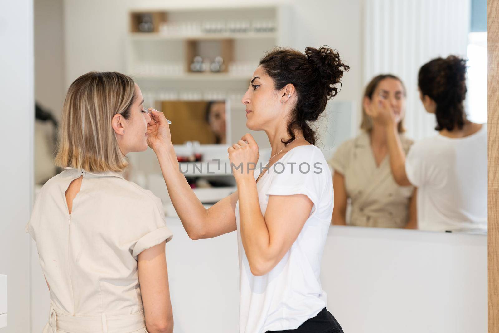 Arab makeup artist making up a woman in a beauty center. by javiindy