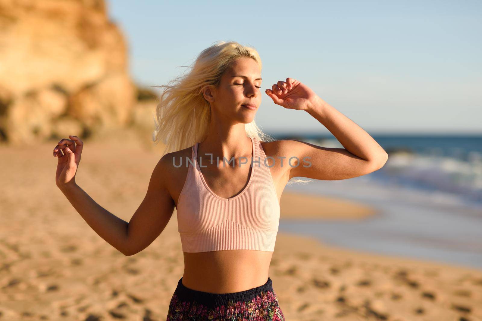 Woman enjoying the sunset on a beautiful beach by javiindy