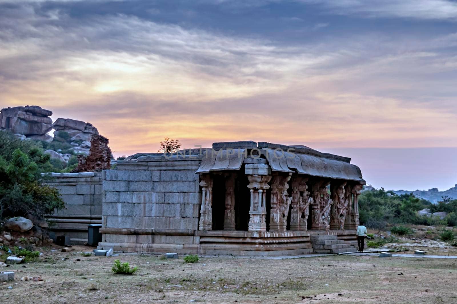 Sunset behind ancient stone temple in Vitthala temple complex in Hampi. by lalam
