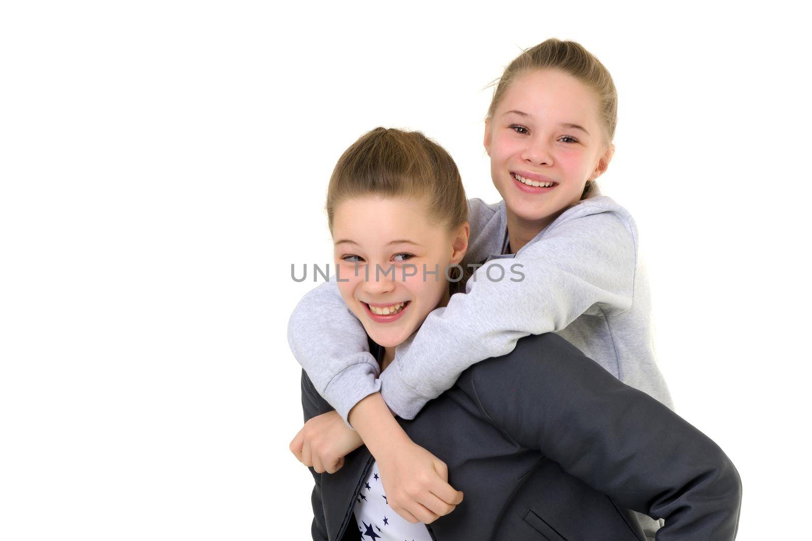Happy Smiling Teen Girl Piggy Backing her Twin Sister by kolesnikov_studio