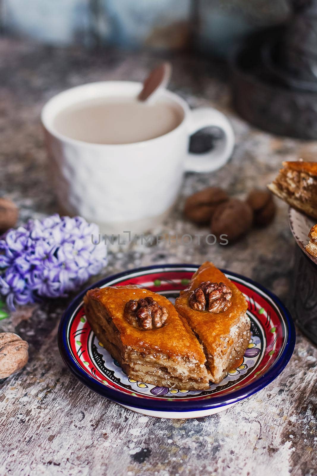 Assorted baklava. A Turkish ramadan arabic sweet dessert on a decorative plate, with coffee cup in the background. Middle eastern food baklava with nuts and honey syrup.