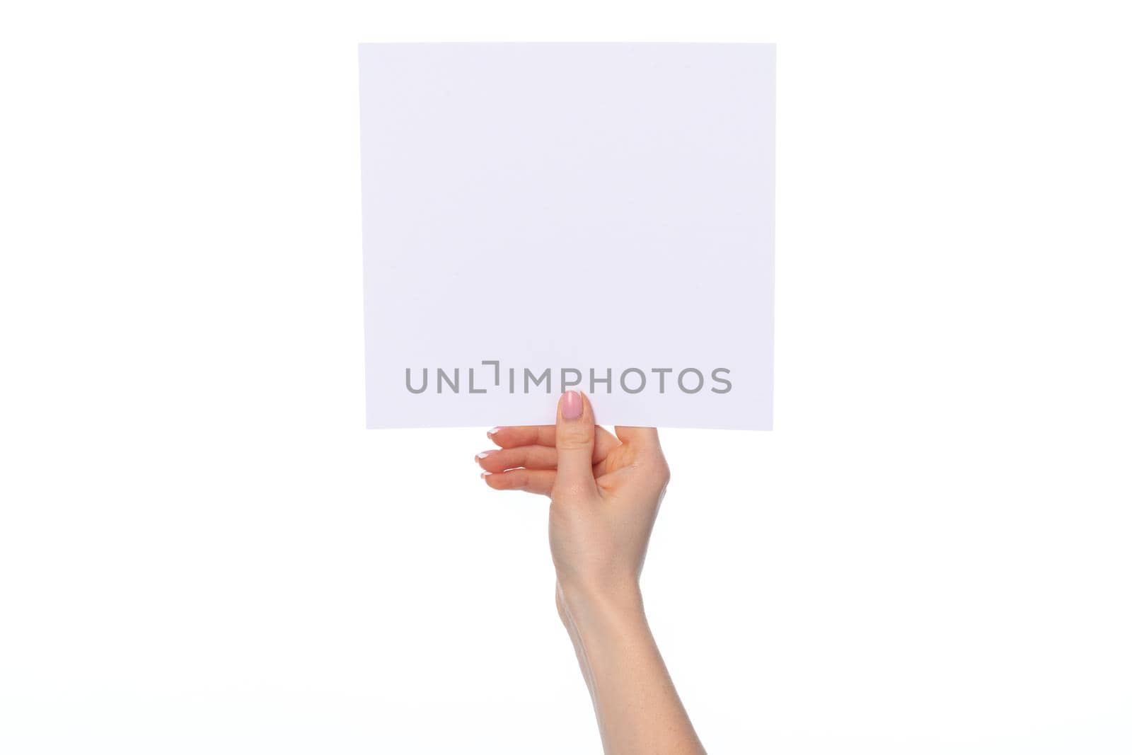 Female hand holding blank white sheet of paper isolated on white background