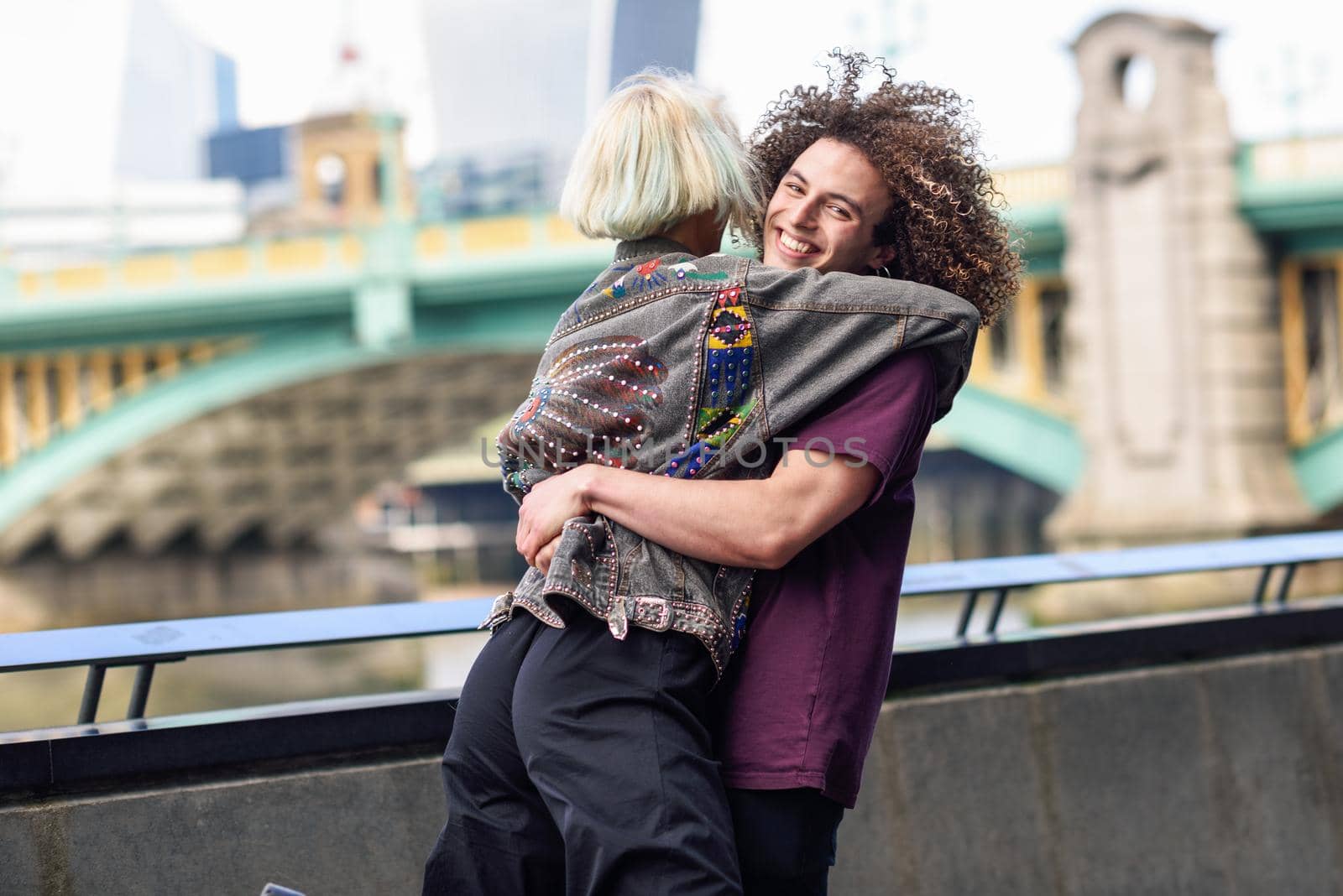 Happy couple hugging near the Southwark bridge over River Thames, London by javiindy