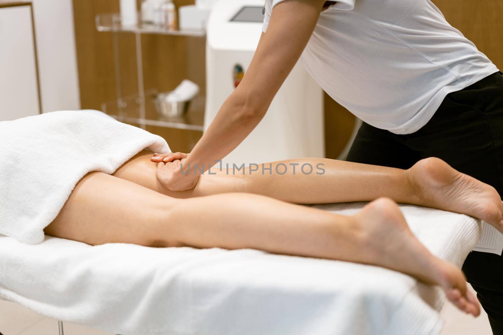 Middle-aged woman having a leg massage in a beauty salon. by javiindy