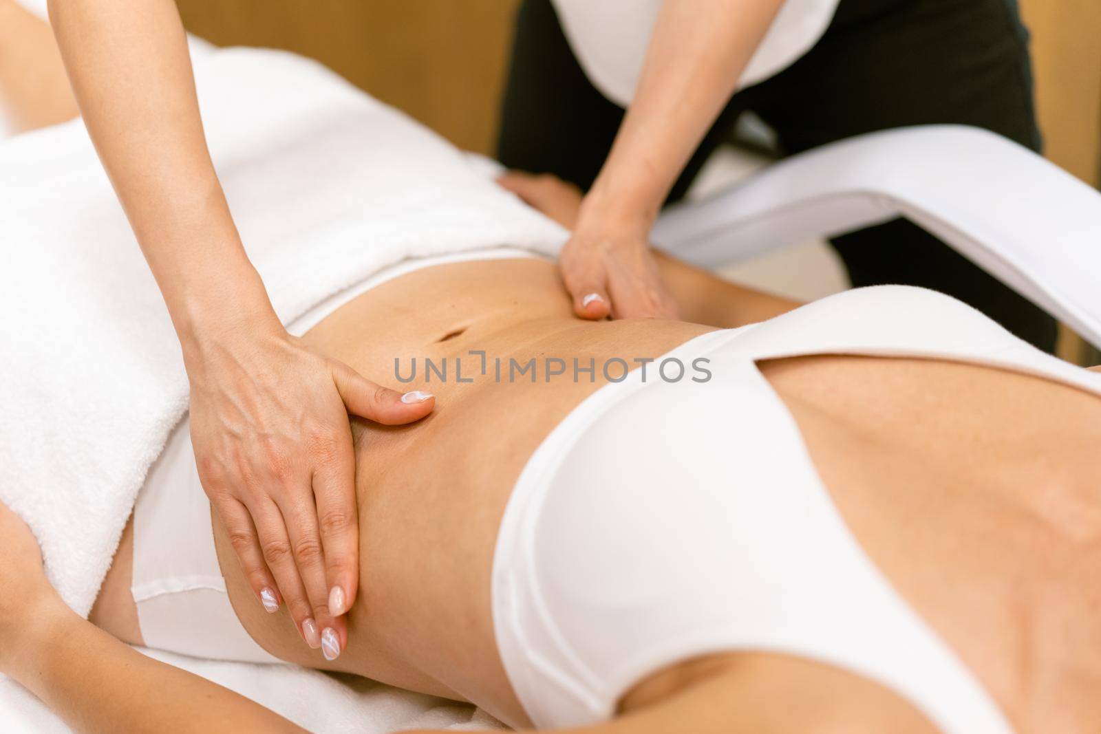 Middle-aged woman having a belly massage in a beauty salon. Body care treatment in a beauty centre.