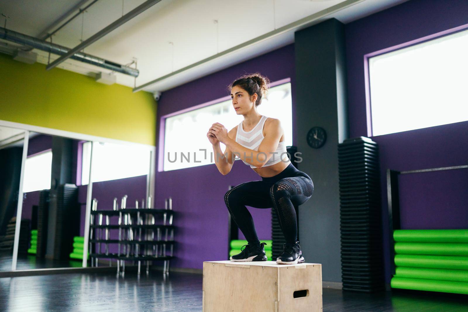 Athletic woman doing squats on box at the gym by javiindy