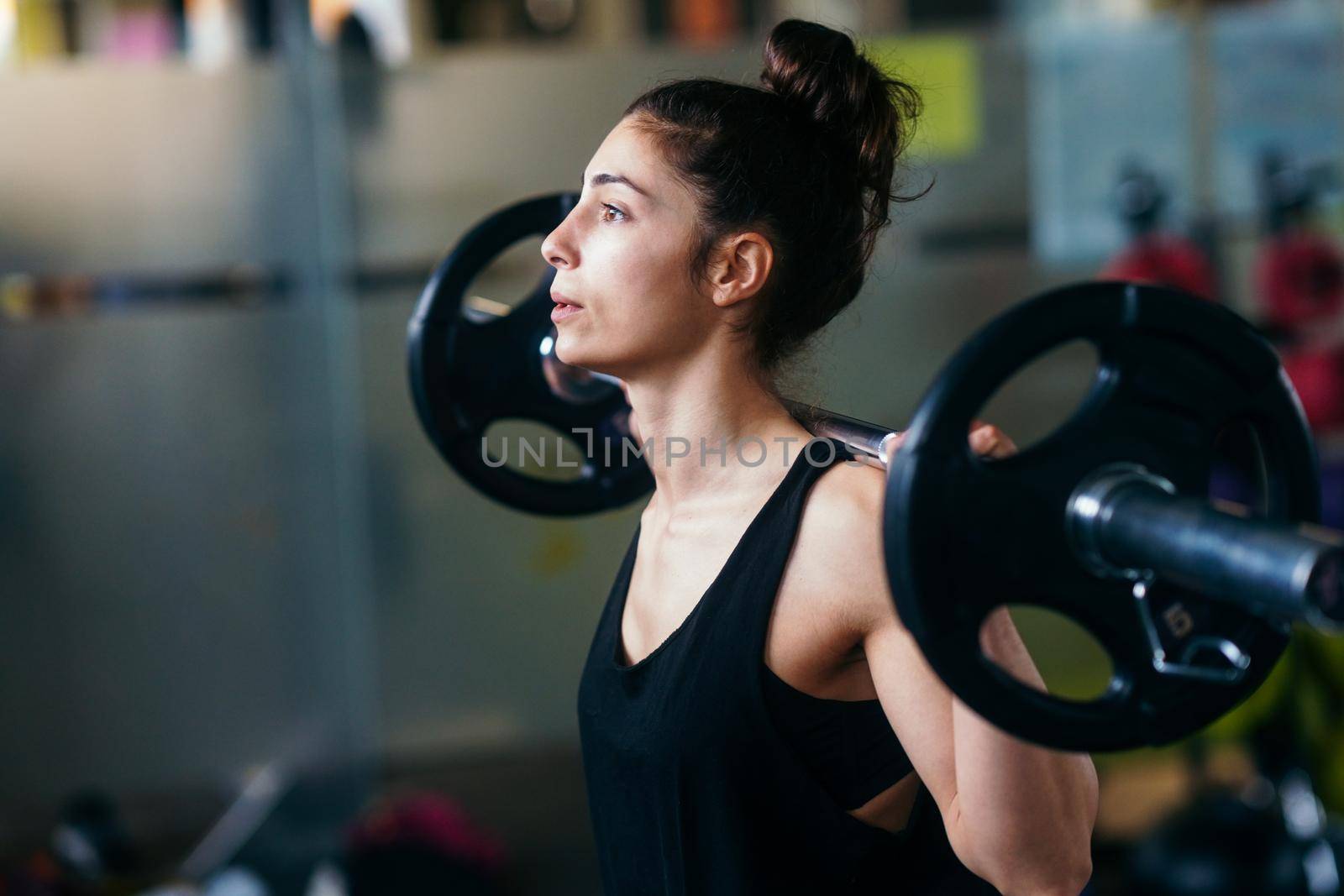 Athletic woman in gym lifting weights at the gym. Fitness concept.