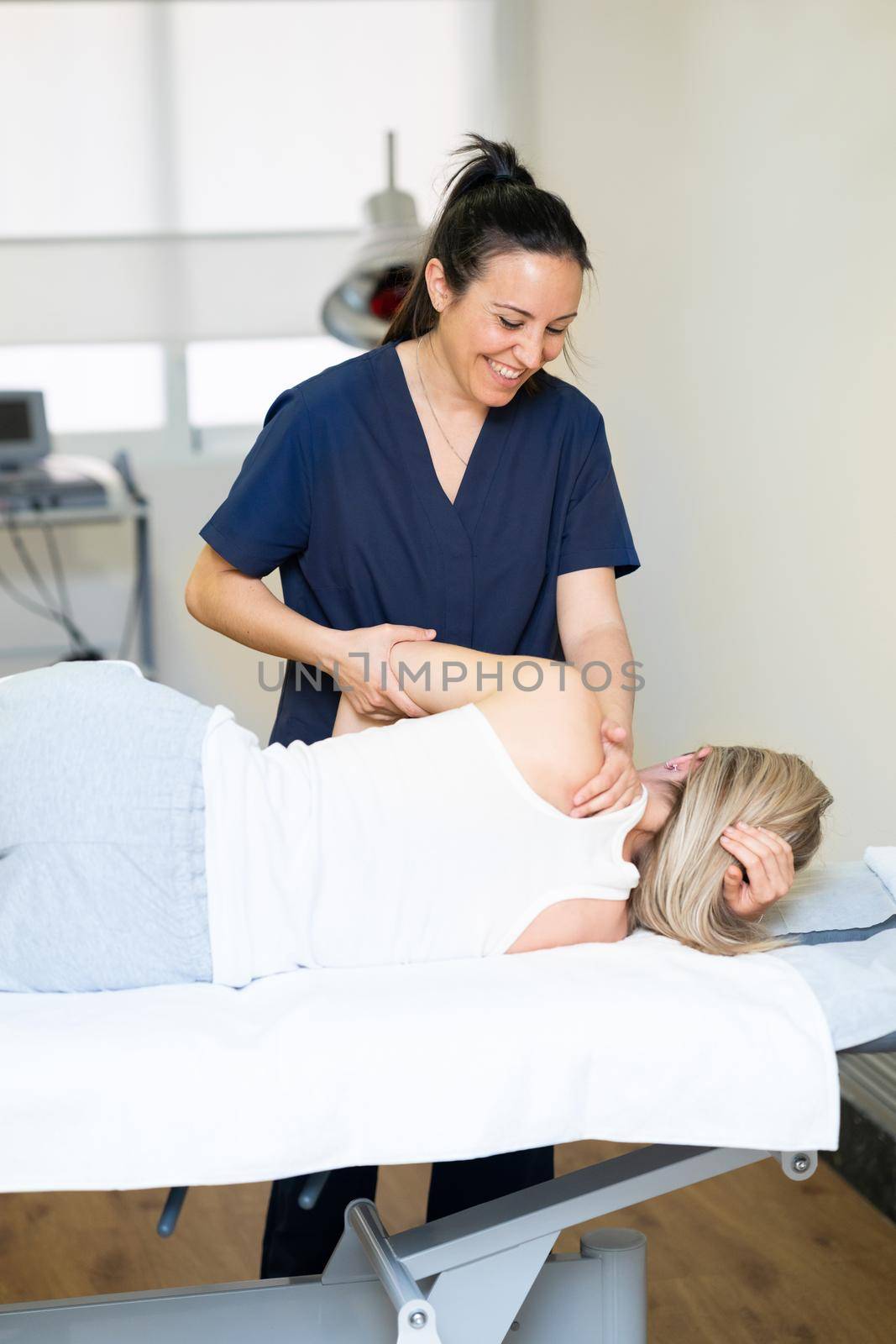 Physiotherapist inspecting her patient in a physiotherapy center. by javiindy