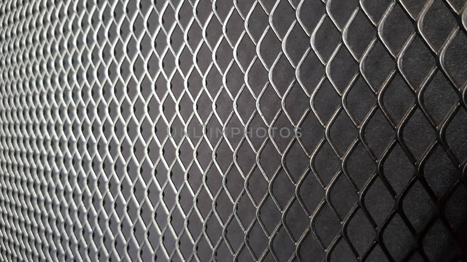 Metal mesh seamless pattern. Black metal mesh texture on a black background. Bulletin board for text and message design. Rhombus shape.