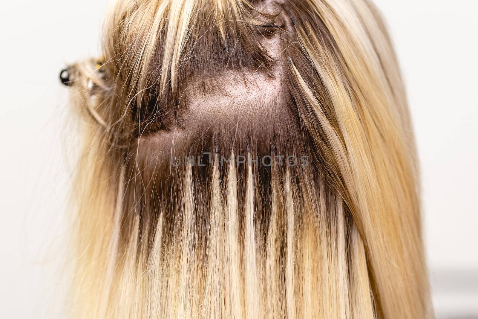 Blonde hair extensions procedure in beauty salon by Syvanych