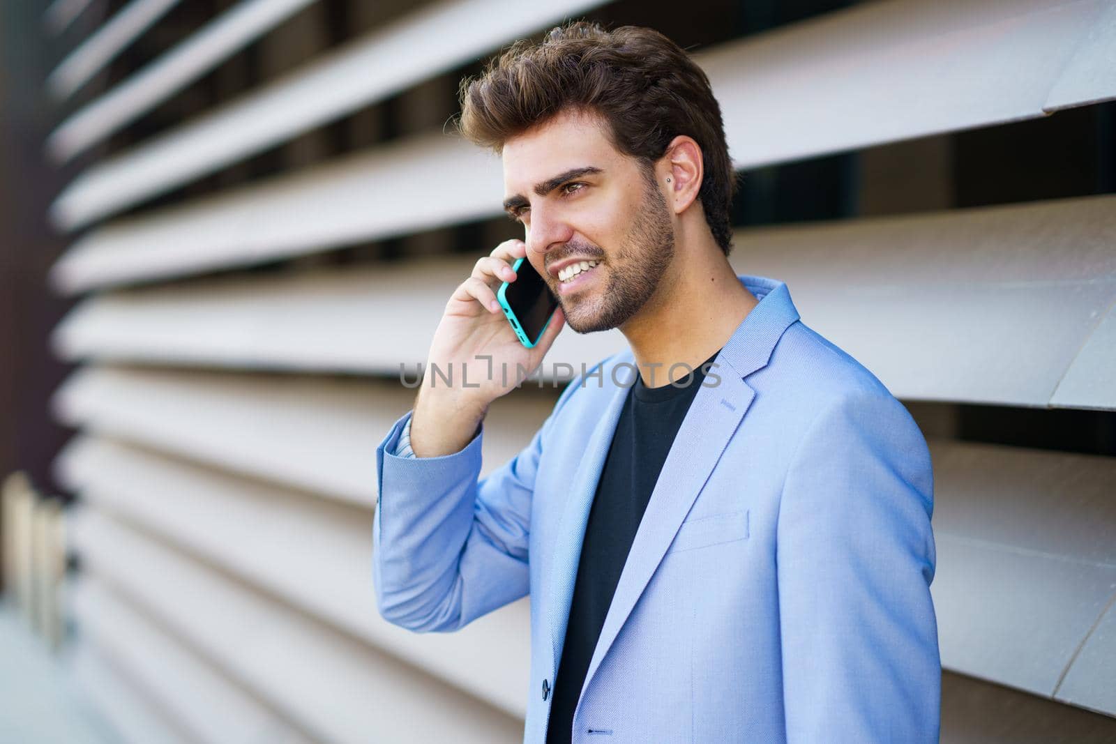 Man talking to his smartphone with a happy expression by javiindy