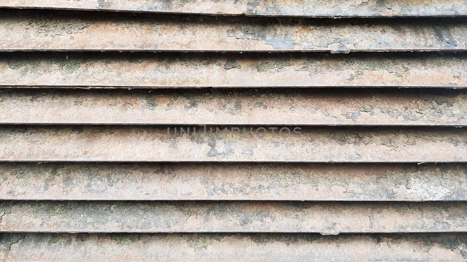 Rusty old ventilation grill on the wall close-up. Old grunge background