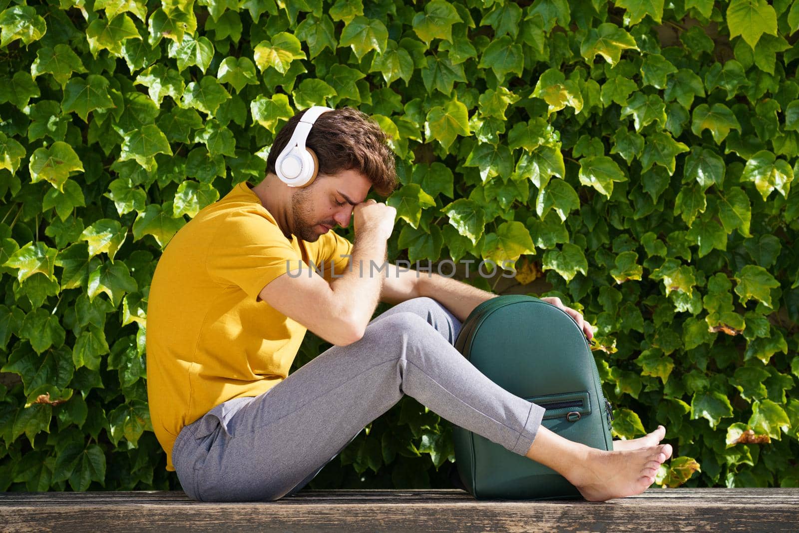 Young student sitting outside worried about his exams by javiindy