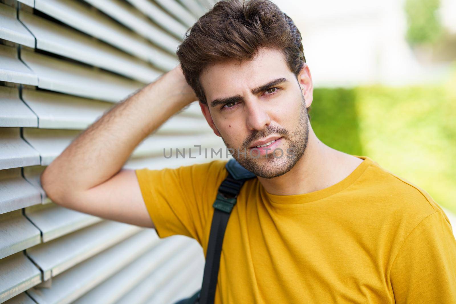 Portrait of young man with modern haircut in urban background
