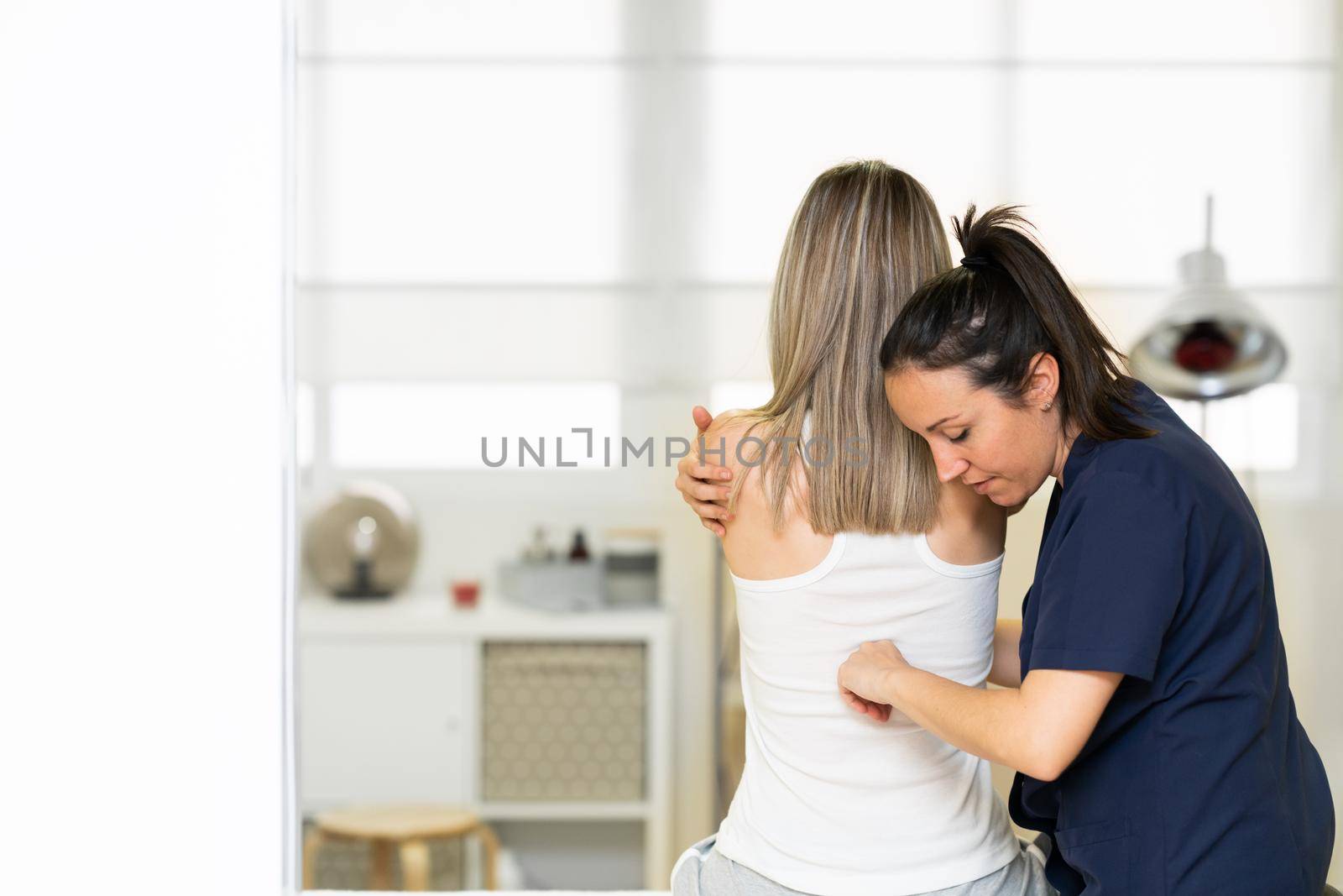 Physiotherapist inspecting her patient in a physiotherapy center. by javiindy