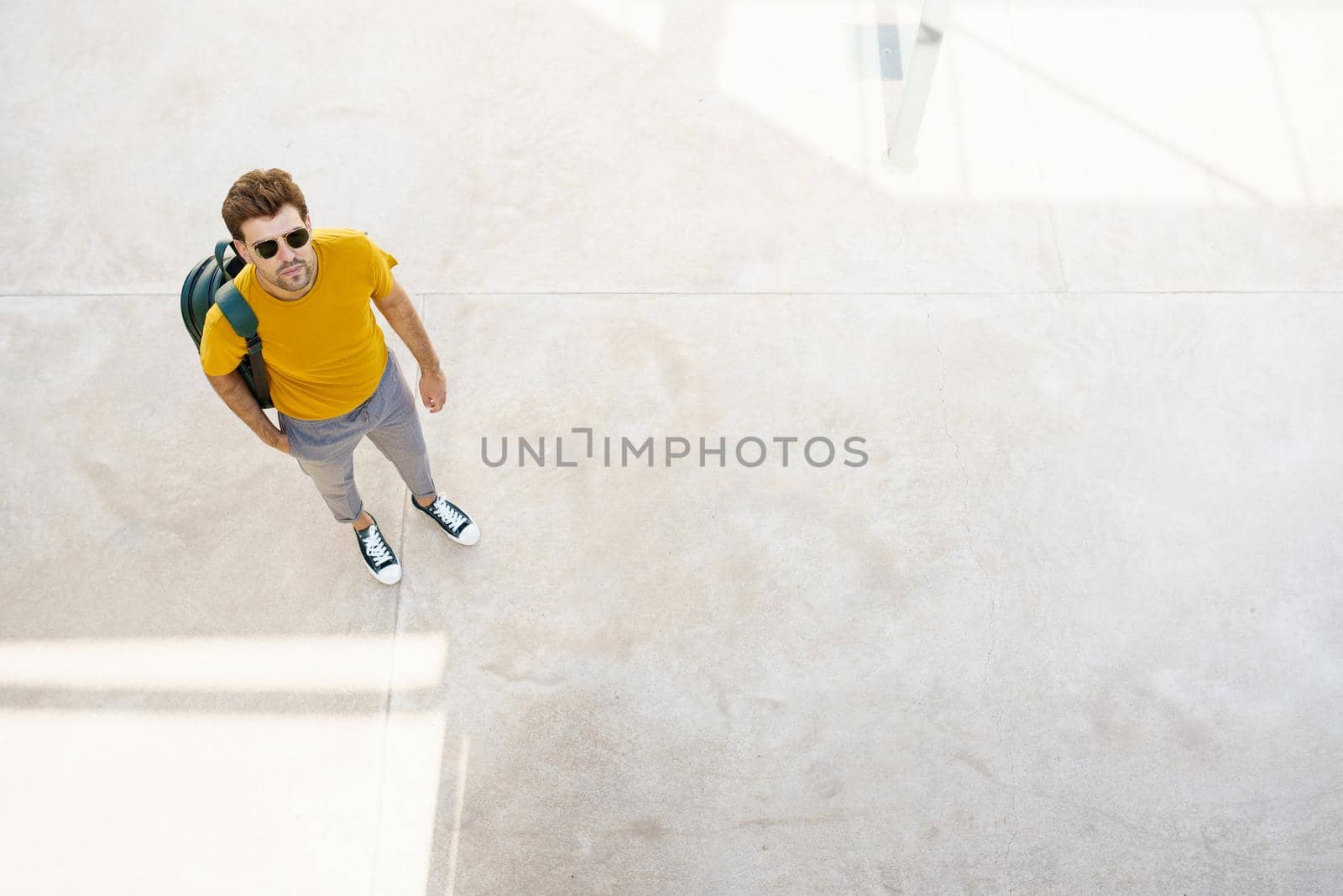 Top view of a male student on the university campus. Young man in urban background.